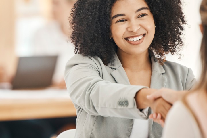 Women shaking hands during onboarding process.